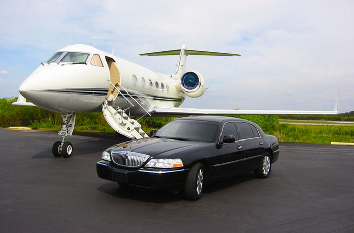 sedan parked infront of private jet